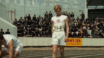 Movie still from “Chariots of Fire” (1981), directed by Hugh Hudson – A man standing on top of a race track in front of a crowd; Medium shot, Low angle