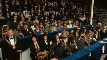 Movie still from “Chariots of Fire” (1981), directed by Hugh Hudson – A group of people sitting in chairs and wearing hats; Wide shot, High angle