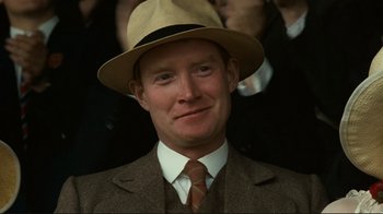 Movie still from “Chariots of Fire” (1981), directed by Hugh Hudson – A man wearing a suit and a hat; Close Up shot, Over the shoulder angle