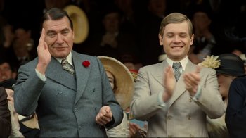 Movie still from “Chariots of Fire” (1981), directed by Hugh Hudson – Two men in grey suits and ties standing next to each other and clapping; Medium shot, Low angle