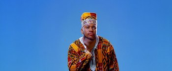 Movie still from “Charlie's Angels” (2000), directed by McG – A man in a colorful outfit is posing for a picture; Medium shot, Low angle