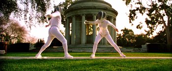 Movie still from “Charlie's Angels” (2000), directed by McG – A couple of people that are fencing in the grass; Wide shot, Low angle