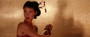 Movie still from “Charlie's Angels” (2000), directed by McG – A woman in a red dress is holding a bracelet; Close Up shot, Over the shoulder angle