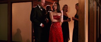Movie still from “Charlie's Angels” (2000), directed by McG – A woman in a red dress standing next to a man in a black suit; Medium shot, Low angle