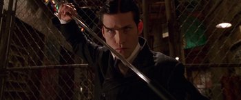Movie still from “Charlie's Angels” (2000), directed by McG – A man holding a sword in his hand; Close Up shot, Low angle
