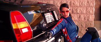 Movie still from “Charlie's Angels” (2000), directed by McG – A woman standing in front of a motorcycle; Medium shot, Low angle