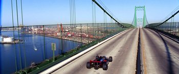 Movie still from “Charlie's Angels” (2000), directed by McG – A red and blue car driving down a bridge; Extreme Wide shot, High angle