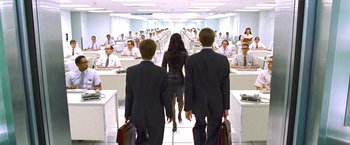 Movie still from “Charlie's Angels” (2000), directed by McG – A group of people standing in a room with desks; Wide shot, High angle