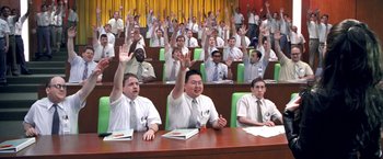 Movie still from “Charlie's Angels” (2000), directed by McG – A group of men sitting at a table with their hands raised; Extreme Wide shot, High angle