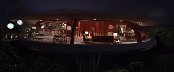 Movie still from “Charlie's Angels” (2000), directed by McG – A woman standing in front of a living room at night; Extreme Wide shot, Low angle