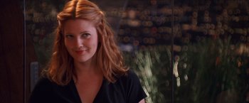 Movie still from “Charlie's Angels” (2000), directed by McG – A beautiful woman with red hair smiling for the camera; Close Up shot, Over the shoulder angle