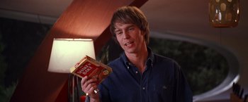 Movie still from “Charlie's Angels” (2000), directed by McG – A young man holding a box of peanut butter; Medium shot, Low angle