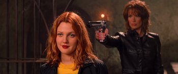 Movie still from “Charlie's Angels” (2000), directed by McG – A woman with red hair is holding a gun; Close Up shot, Over the shoulder angle