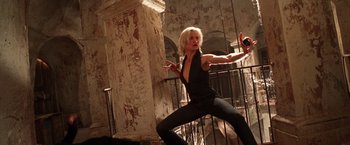 Movie still from “Charlie's Angels” (2000), directed by McG – A woman in a black top is doing a dance move; Medium shot, Low angle