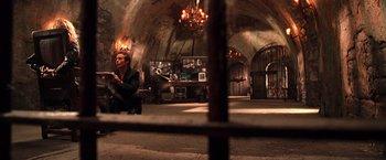 Movie still from “Charlie's Angels” (2000), directed by McG – A man sitting on a chair inside of a room; Wide shot, High angle