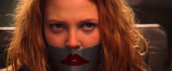 Movie still from “Charlie's Angels” (2000), directed by McG – A woman with red hair and a duct tape over her mouth; Extreme Close Up shot, Low angle