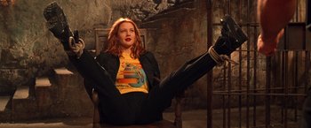 Movie still from “Charlie's Angels” (2000), directed by McG – A woman sitting in a chair with her legs crossed; Medium shot, Low angle