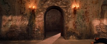 Movie still from “Charlie's Angels” (2000), directed by McG – An arched doorway in a stone building with lights; Wide shot, High angle