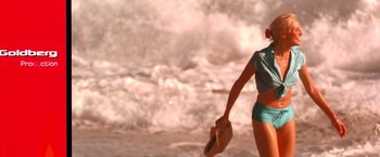 Movie still from “Charlie's Angels” (2000), directed by McG – A woman walking on the beach holding a hat; Medium shot, High angle