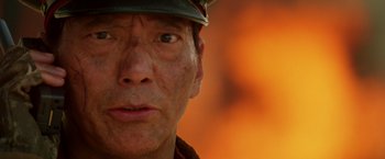 Movie still from “Charlie's Angels: Full Throttle” (2003), directed by McG – A man's face in front of an orange background; Extreme Close Up shot, Low angle