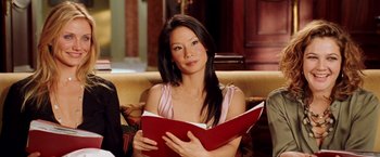 Movie still from “Charlie's Angels: Full Throttle” (2003), directed by McG – A woman sitting on a couch holding a red book; Close Up shot, Over the shoulder angle