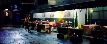 Movie still from “Charlie's Angels: Full Throttle” (2003), directed by McG – Tables and chairs are set up outside of a restaurant at night; Extreme Wide shot, High angle
