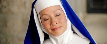 Movie still from “Charlie's Angels: Full Throttle” (2003), directed by McG – A woman wearing a nun's outfit with her eyes closed; Extreme Close Up shot, Overhead angle