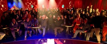 Movie still from “Charlie's Angels: Full Throttle” (2003), directed by McG – A large group of people sitting in a room; Wide shot, High angle