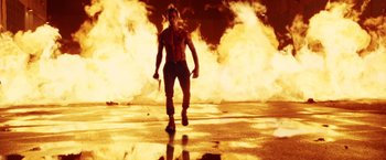 Movie still from “Charlie's Angels: Full Throttle” (2003), directed by McG – A man is walking in front of a fire; Wide shot, Low angle