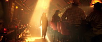 Movie still from “Charlie's Angels: Full Throttle” (2003), directed by McG – A woman walking in front of a group of diners; Wide shot, Low angle