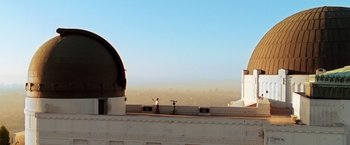 Movie still from “Charlie's Angels: Full Throttle” (2003), directed by McG – A man standing on top of a building near a telescope; Extreme Wide shot, Low angle
