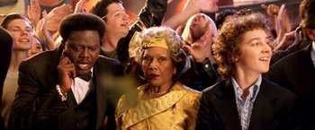 Movie still from “Charlie's Angels: Full Throttle” (2003), directed by McG – An older woman in a yellow dress and a bunch of people; Close Up shot, High angle
