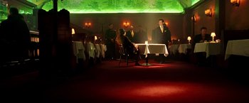 Movie still from “Charlie's Angels: Full Throttle” (2003), directed by McG – A group of people sitting at a table in a room; Wide shot, High angle