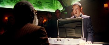 Movie still from “Charlie's Angels: Full Throttle” (2003), directed by McG – A group of men standing around a table; Medium shot, Over the shoulder angle