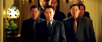 Movie still from “Charlie's Angels: Full Throttle” (2003), directed by McG – A group of men in suits and ties standing in front of a wall; Medium shot, High angle