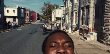 Movie still from “Charm City Kings” (2020), directed by Angel Manuel Soto – A man taking a selfie on the side of the street; Close Up shot, High angle