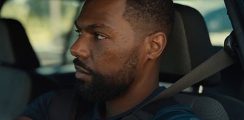 Movie still from “Charm City Kings” (2020), directed by Angel Manuel Soto – A person in a car looking to his left; Close Up shot, Over the shoulder angle