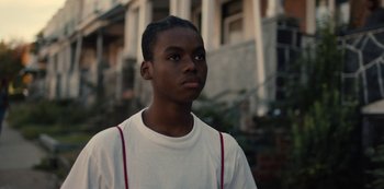Movie still from “Charm City Kings” (2020), directed by Angel Manuel Soto – A young black man standing in front of a brick building; Close Up shot, Low angle