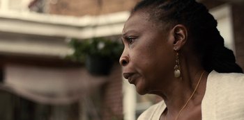 Movie still from “Charm City Kings” (2020), directed by Angel Manuel Soto – An older black woman looking to her left; Close Up shot, Over the shoulder angle