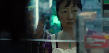 Movie still from “Charm City Kings” (2020), directed by Angel Manuel Soto – An older asian woman looking out of a window; Close Up shot, Low angle