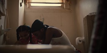 Movie still from “Charm City Kings” (2020), directed by Angel Manuel Soto – Two young people sitting on a bed in a room; Medium shot, Low angle