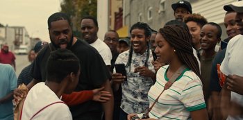 Movie still from “Charm City Kings” (2020), directed by Angel Manuel Soto – A group of people standing next to each other on the street; Medium shot, Over the shoulder angle