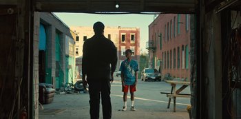 Movie still from “Charm City Kings” (2020), directed by Angel Manuel Soto – A man and a boy standing on a street; Wide shot, Over the shoulder angle