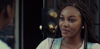 Movie still from “Charm City Kings” (2020), directed by Angel Manuel Soto – A woman with braids is posing for a picture; Close Up shot, Over the shoulder angle