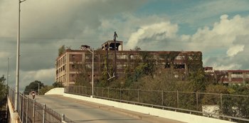 Movie still from “Charm City Kings” (2020), directed by Angel Manuel Soto – A person on a skate board in the air over a building; Extreme Wide shot, Low angle