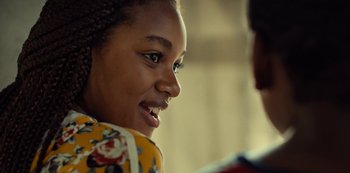 Movie still from “Charm City Kings” (2020), directed by Angel Manuel Soto – A child smiling at the camera; Close Up shot, Over the shoulder angle