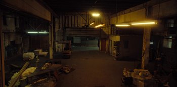 Movie still from “Charm City Kings” (2020), directed by Angel Manuel Soto – An empty warehouse is lit up at night time; Extreme Wide shot, High angle