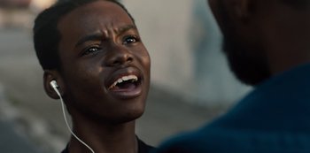 Movie still from “Charm City Kings” (2020), directed by Angel Manuel Soto – A young black man with headphones on looking up at the sky; Close Up shot, Low angle