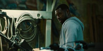 Movie still from “Charm City Kings” (2020), directed by Angel Manuel Soto – A man standing in front of a wall with graffiti on it; Medium shot, Over the shoulder angle