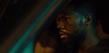 Movie still from “Charm City Kings” (2020), directed by Angel Manuel Soto – A person with a beard looking out a car window; Close Up shot, Over the shoulder angle